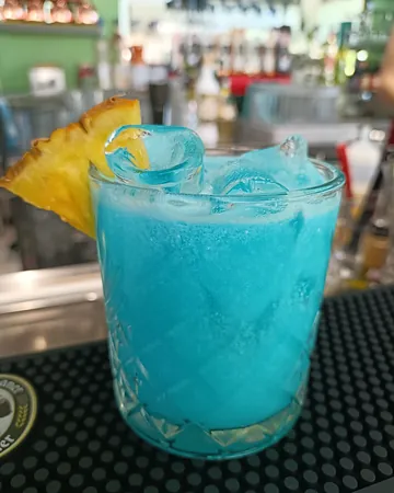 Cocktail blu con ghiaccio e ananas