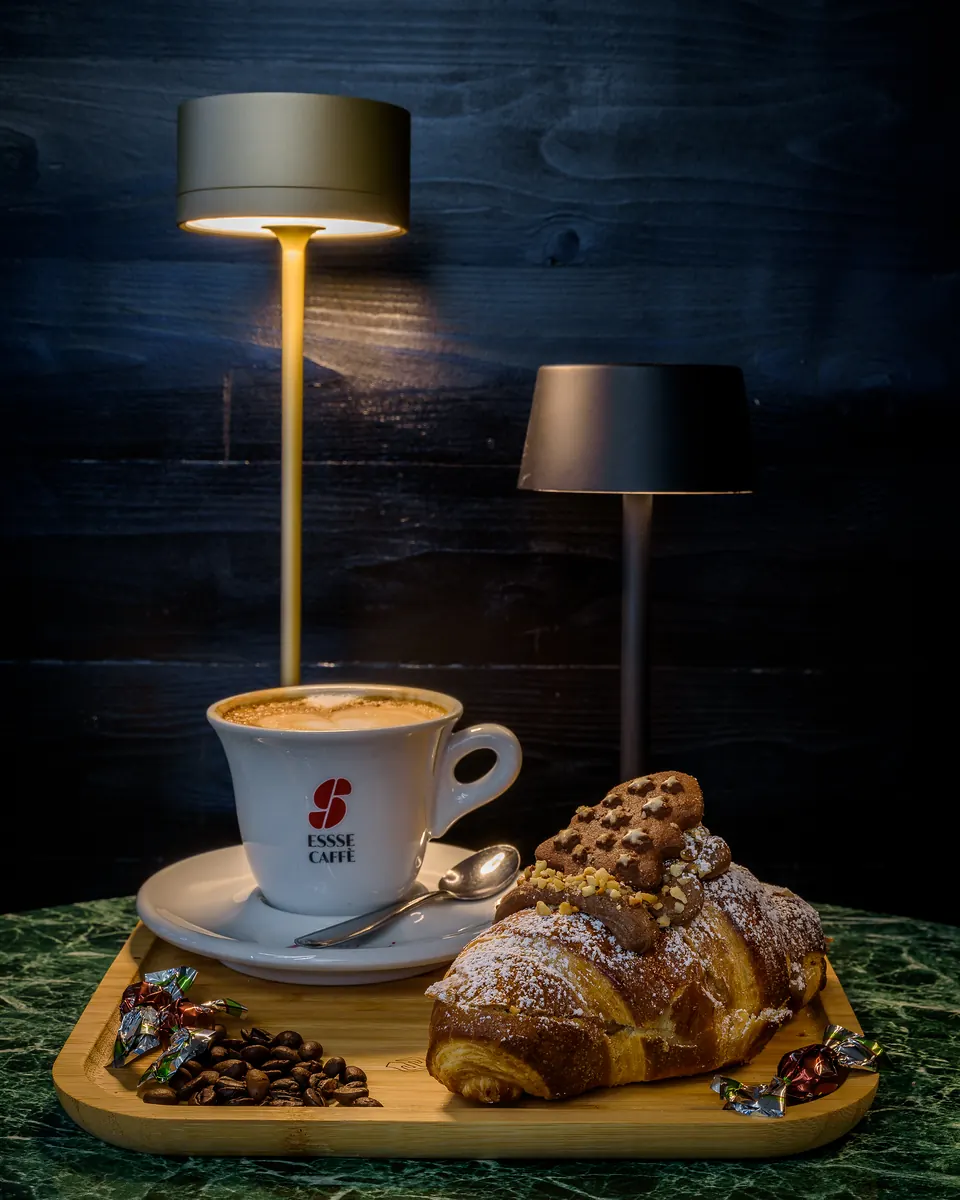Cappuccino in tazza Essse Caffè con un cornetto al cioccolato